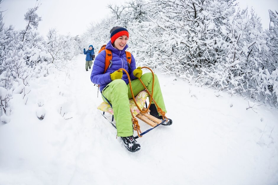 Kobieta zjeżdżającą na drewnianych sankach